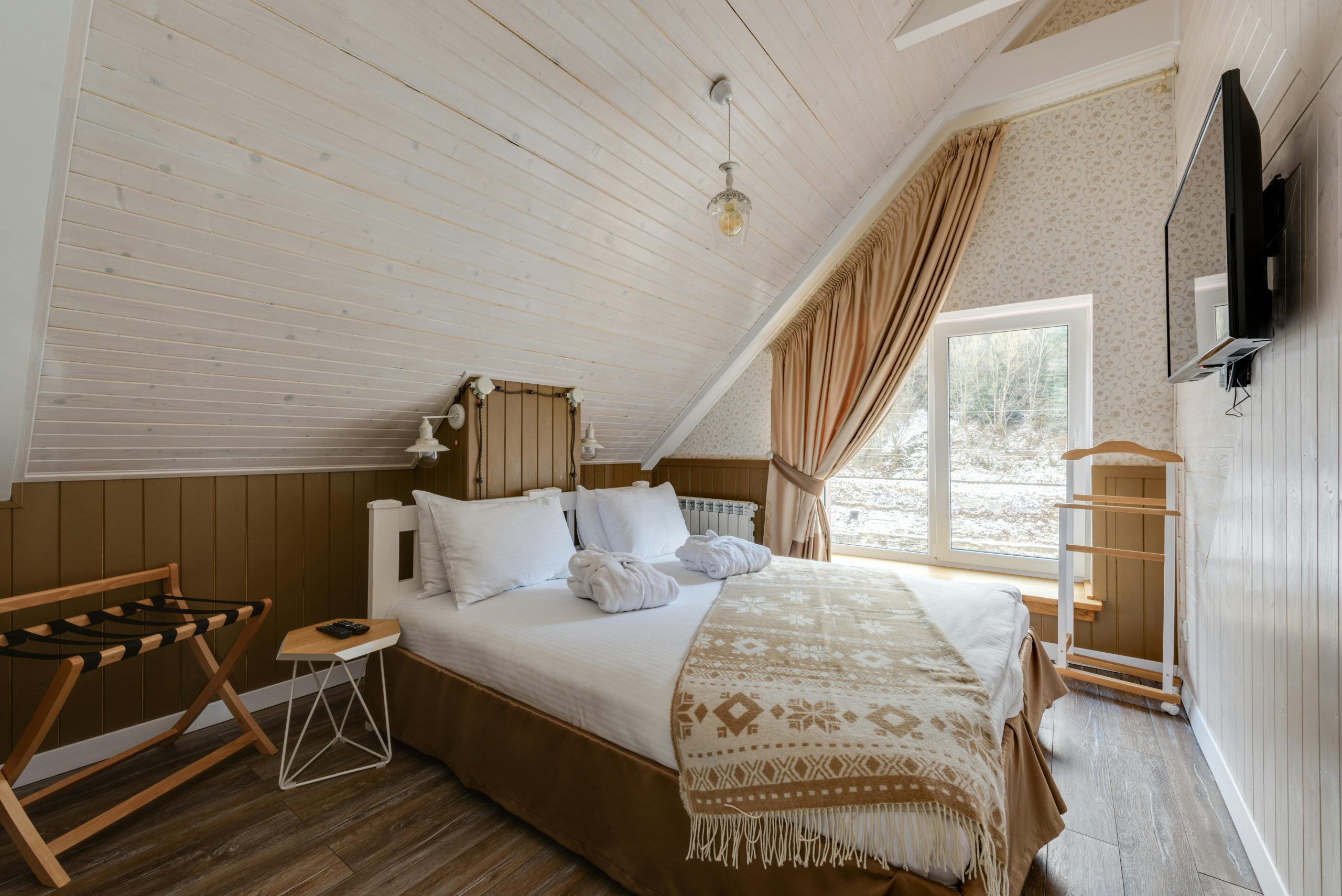 Chambre cosy aménagée sous combles avec textiles chaleureux et matières naturelles