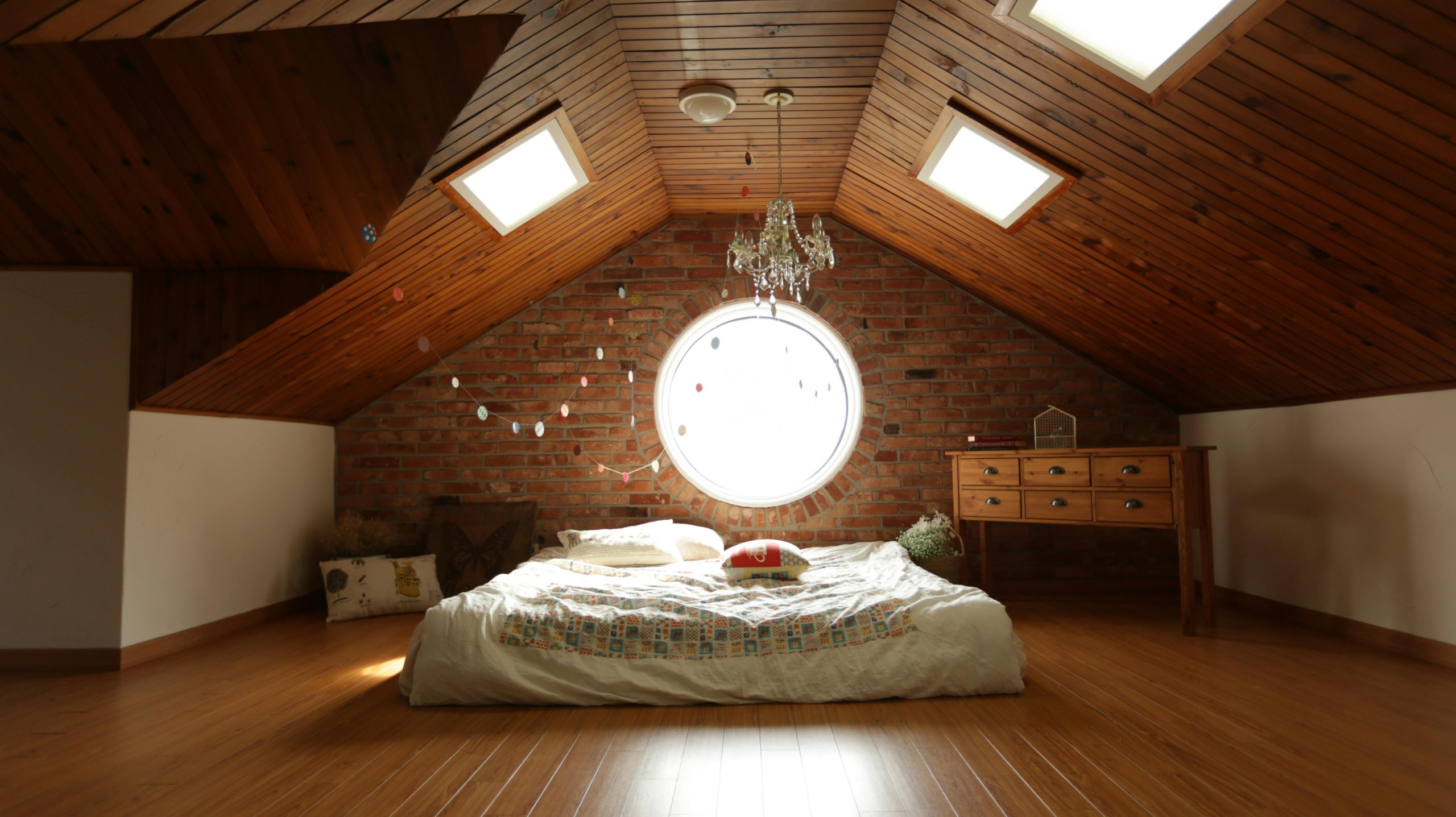 Stratégie d'optimisation visuelle d'une chambre mansardée avec couleurs claires et miroirs