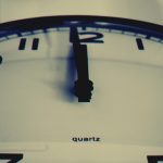 Gros plan détaillé d'une horloge murale montrant l'aiguille des heures à minuit, mettant en évidence le concept du temps.
