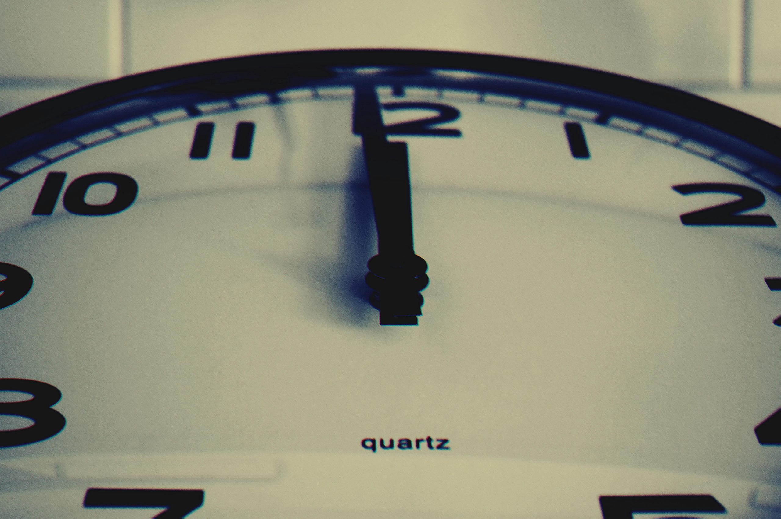 Gros plan détaillé d'une horloge murale montrant l'aiguille des heures à minuit, mettant en évidence le concept du temps.