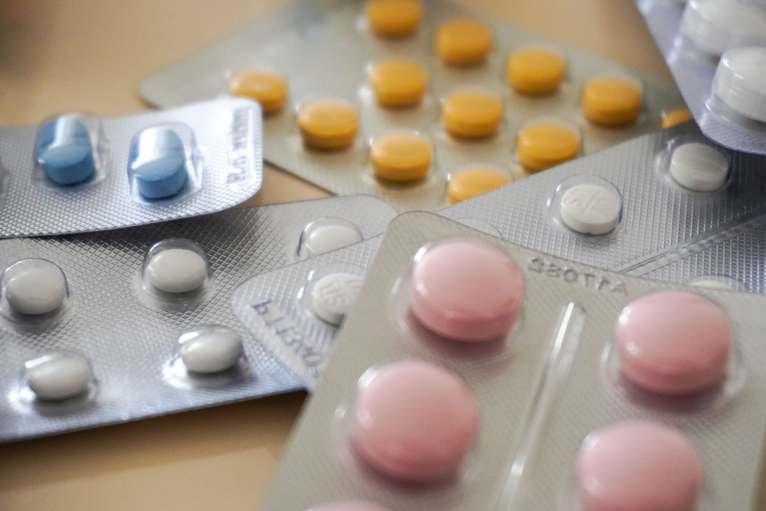 Close-up view of assorted colorful medication blister packs with diverse pills. Vue rapprochée de plaquettes de médicaments colorées assorties contenant diverses pilules.