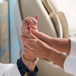Mains qui massent une zone de peau en douceur