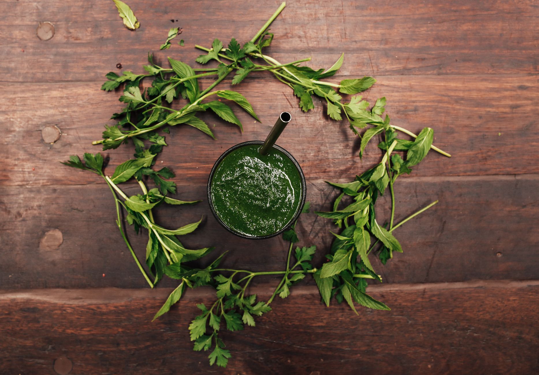 Smoothie vert entouré d herbes fraiches