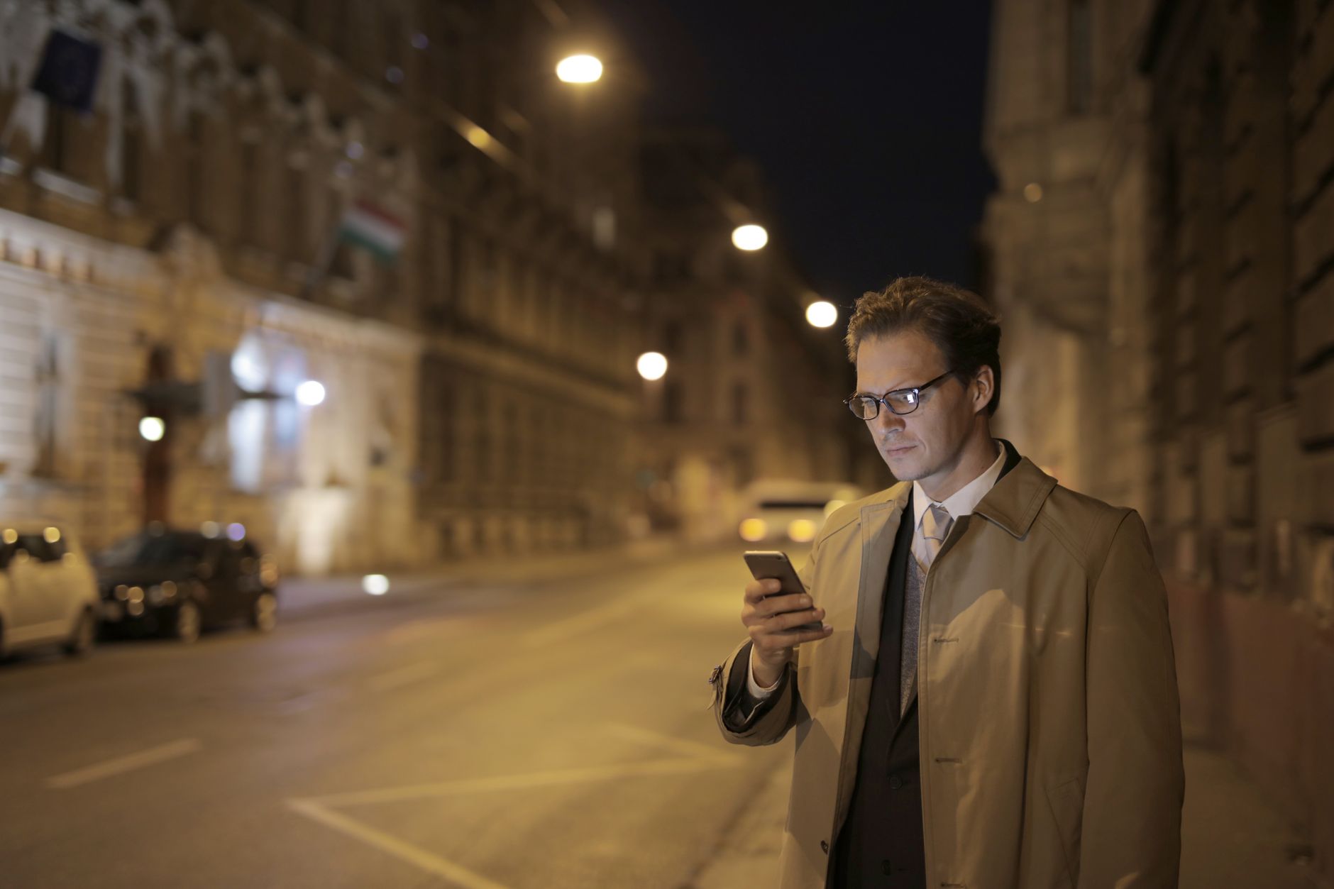 Homme qui consulte son téléphone la nuit dans la rue