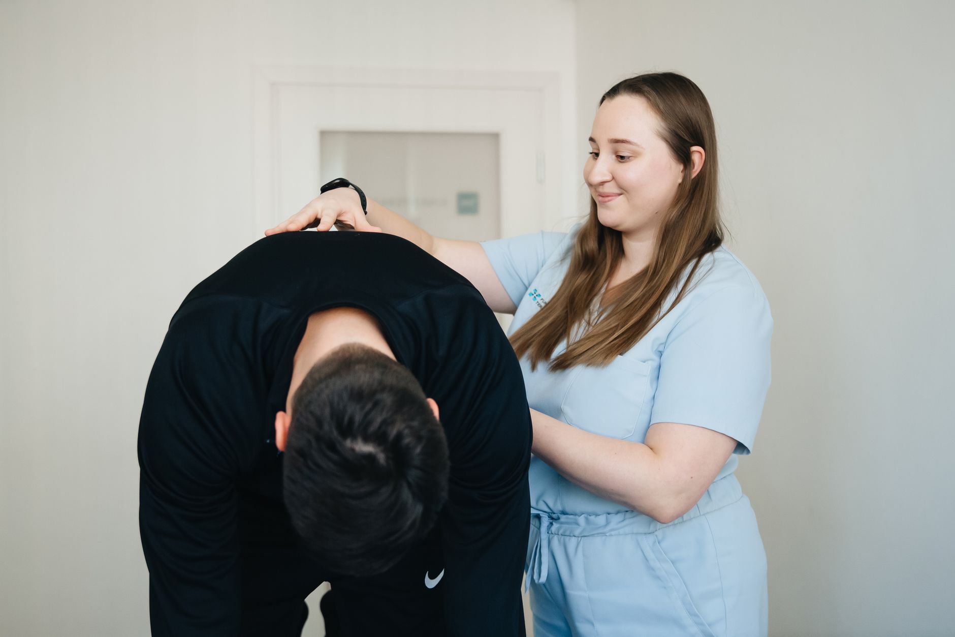 Kinésithérapeute souriant aidant un patient pour le dos
