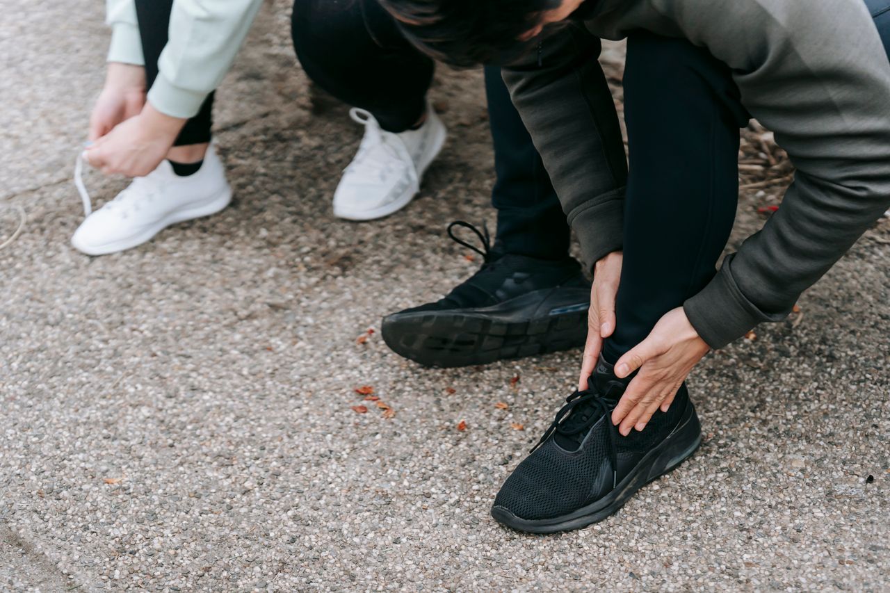 Deux personnes lacent leurs chaussures de sport