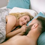 Couple partageant un moment de tendresse au lit