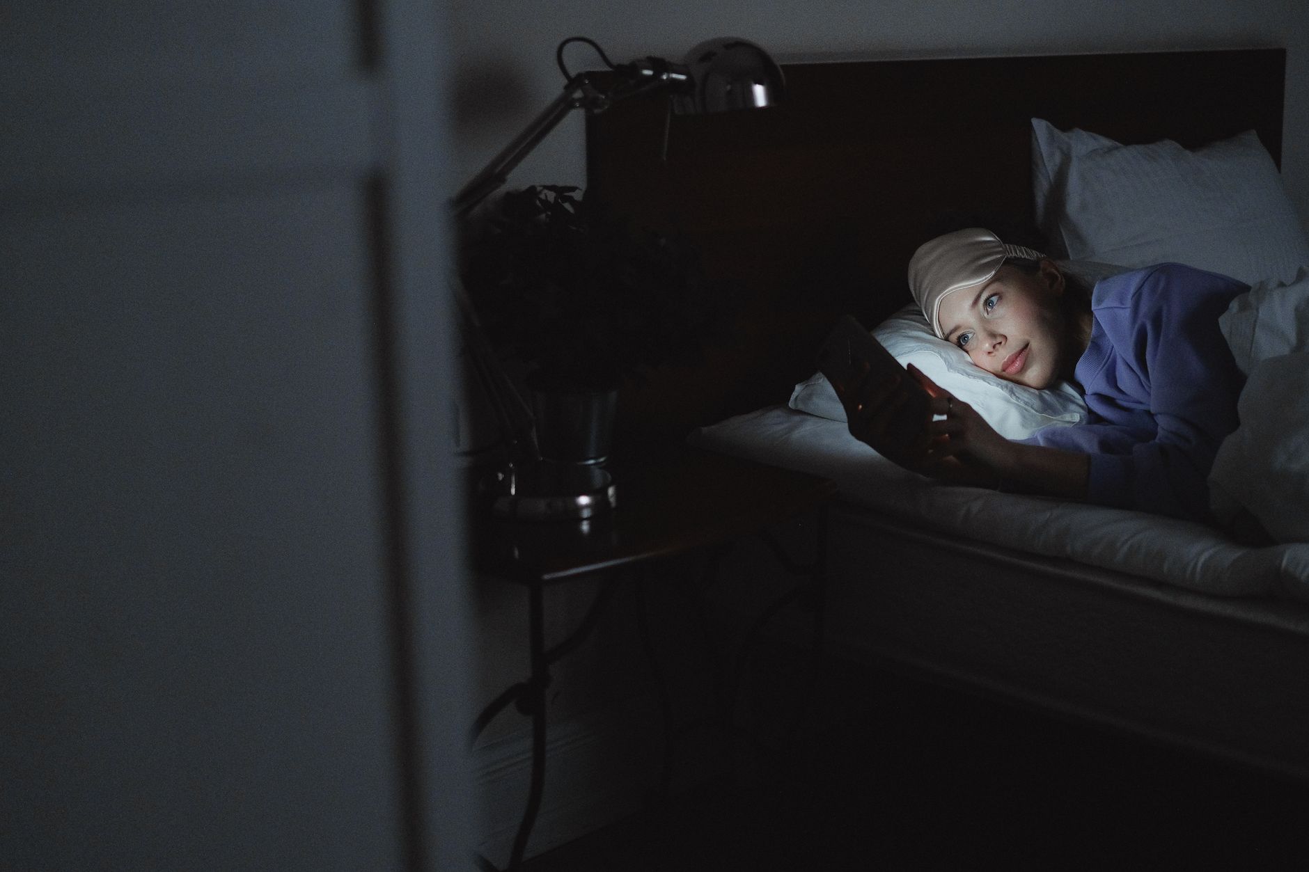 Femme allongée qui lit un message le soir