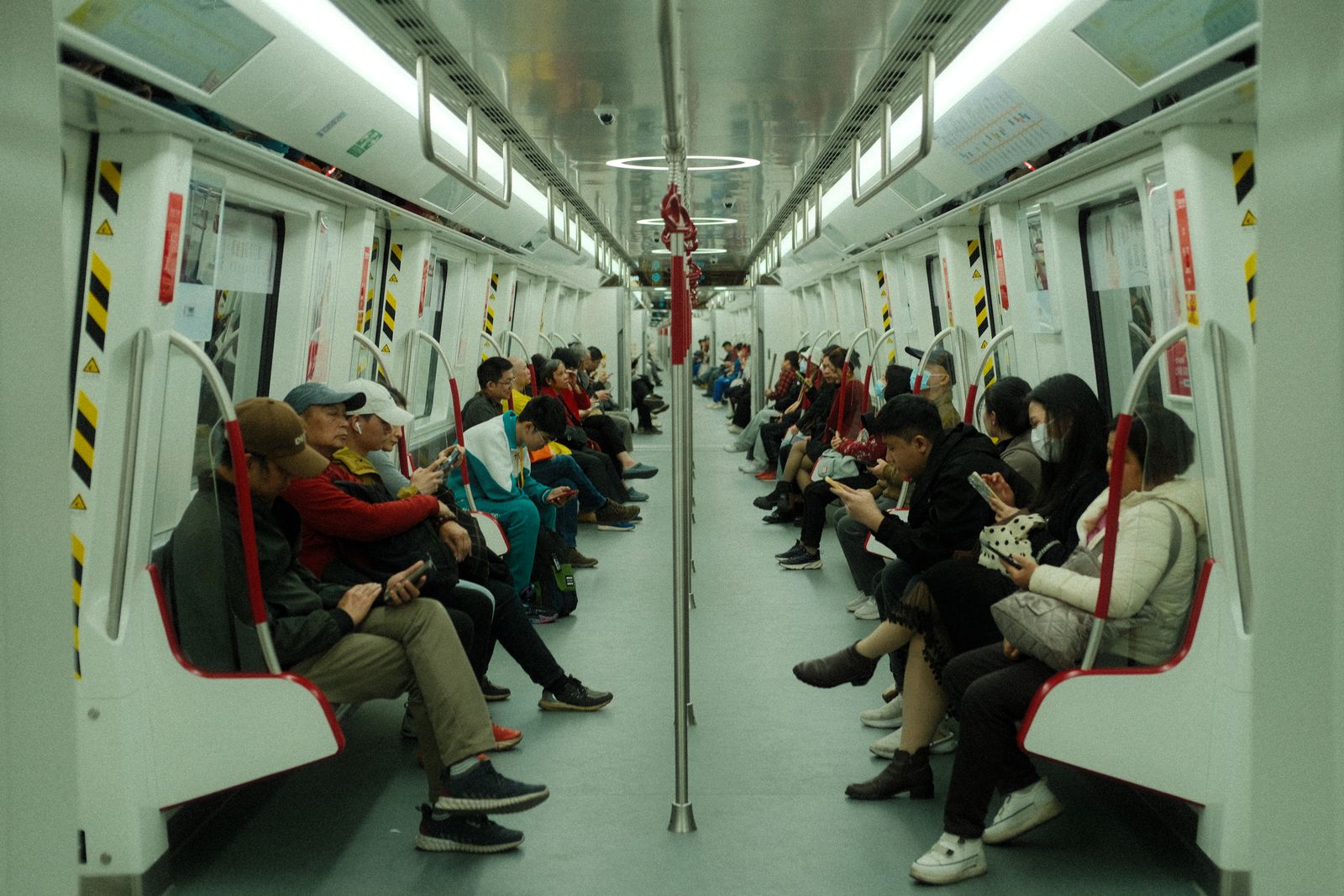 Passagers consultant leur téléphone dans une rame de métro