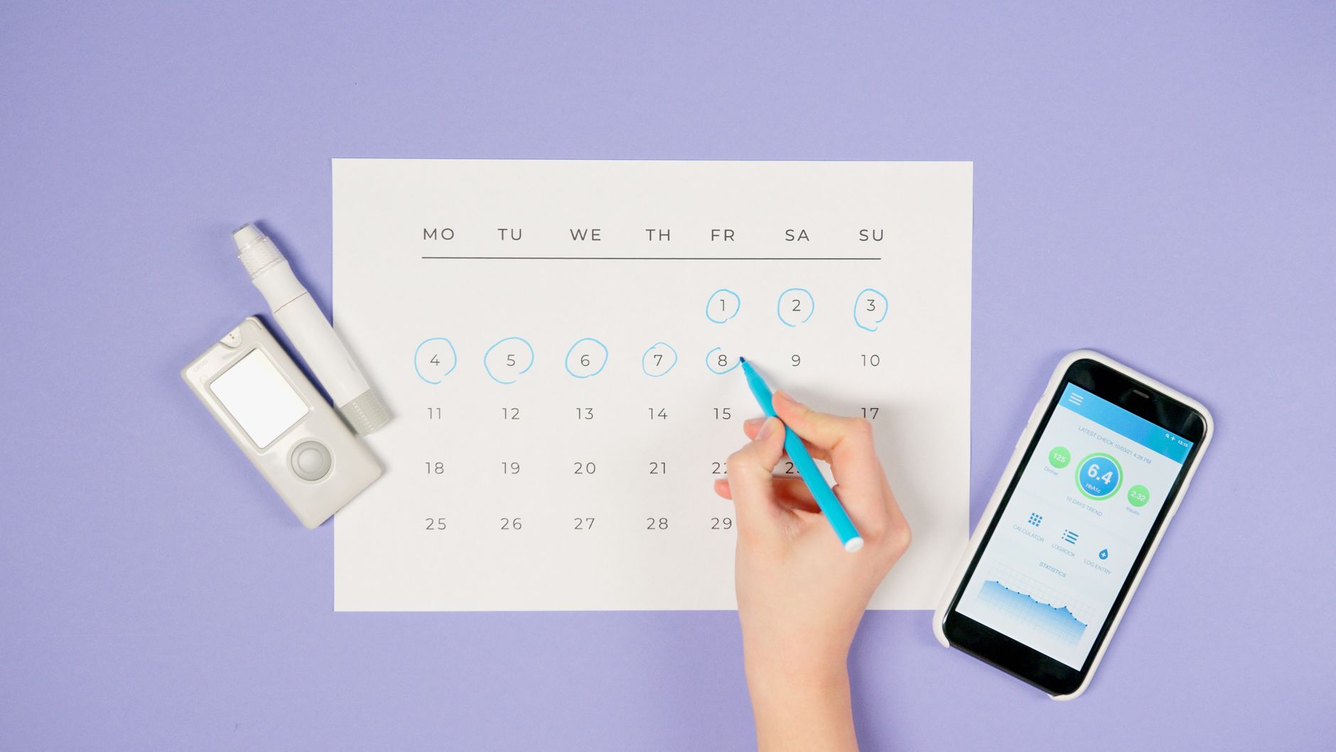 Main marquant les jours sur un calendrier papier