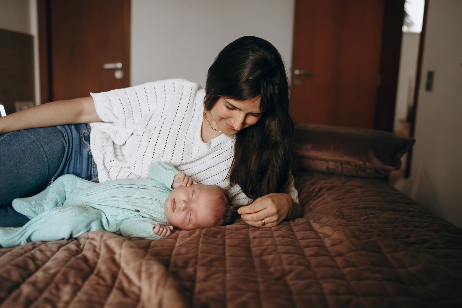 Une jeune mère veille sur son nouveau-né endormi