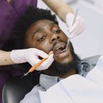 Dentiste qui examine les dents d un patient