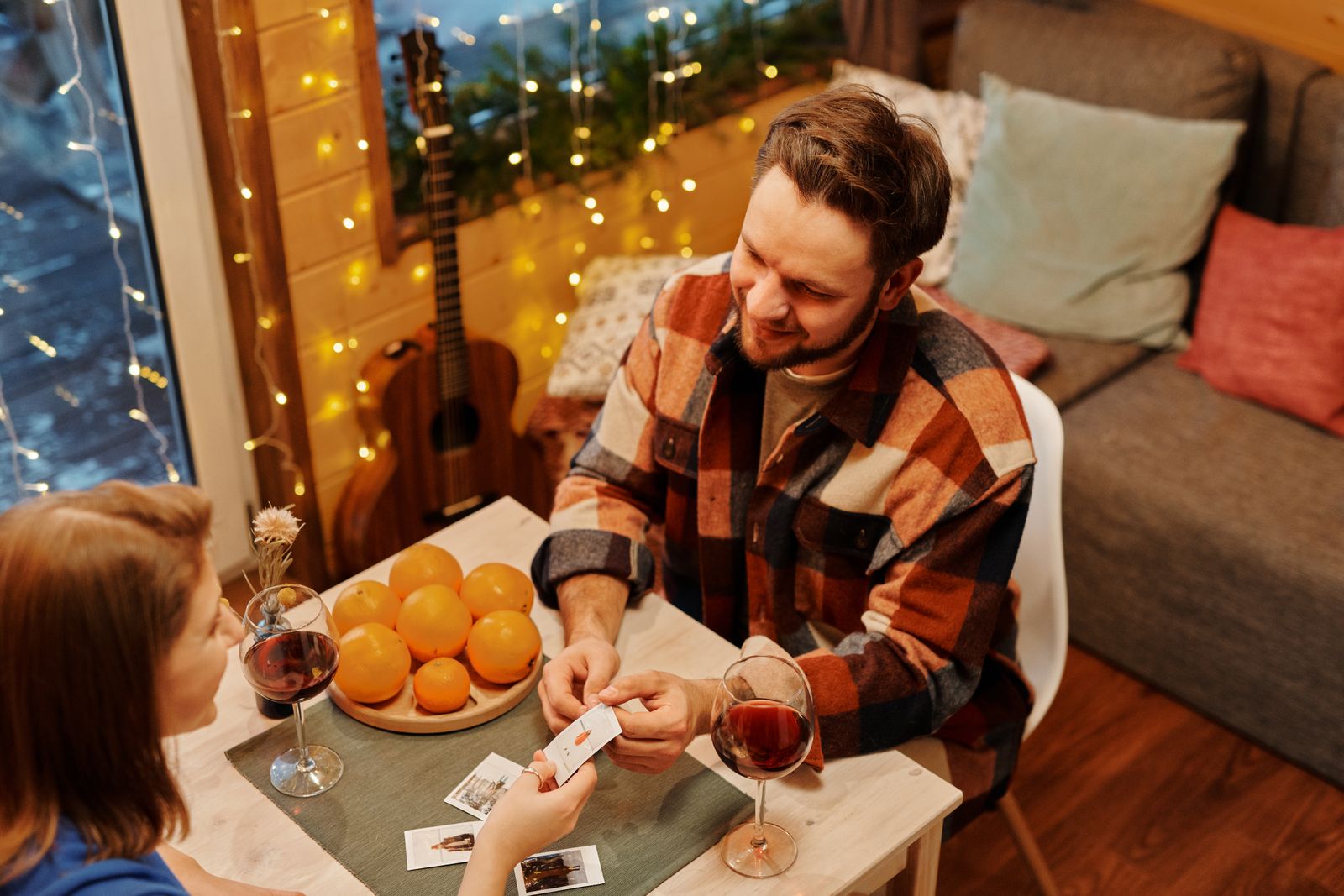 Couple qui joue aux cartes autour d’un verre de vin