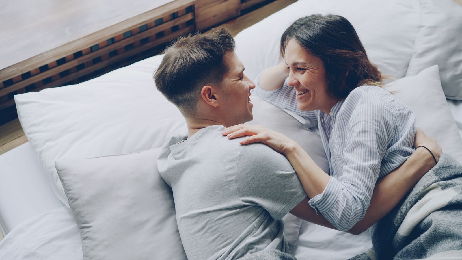 Couple complice qui rit sur un lit
