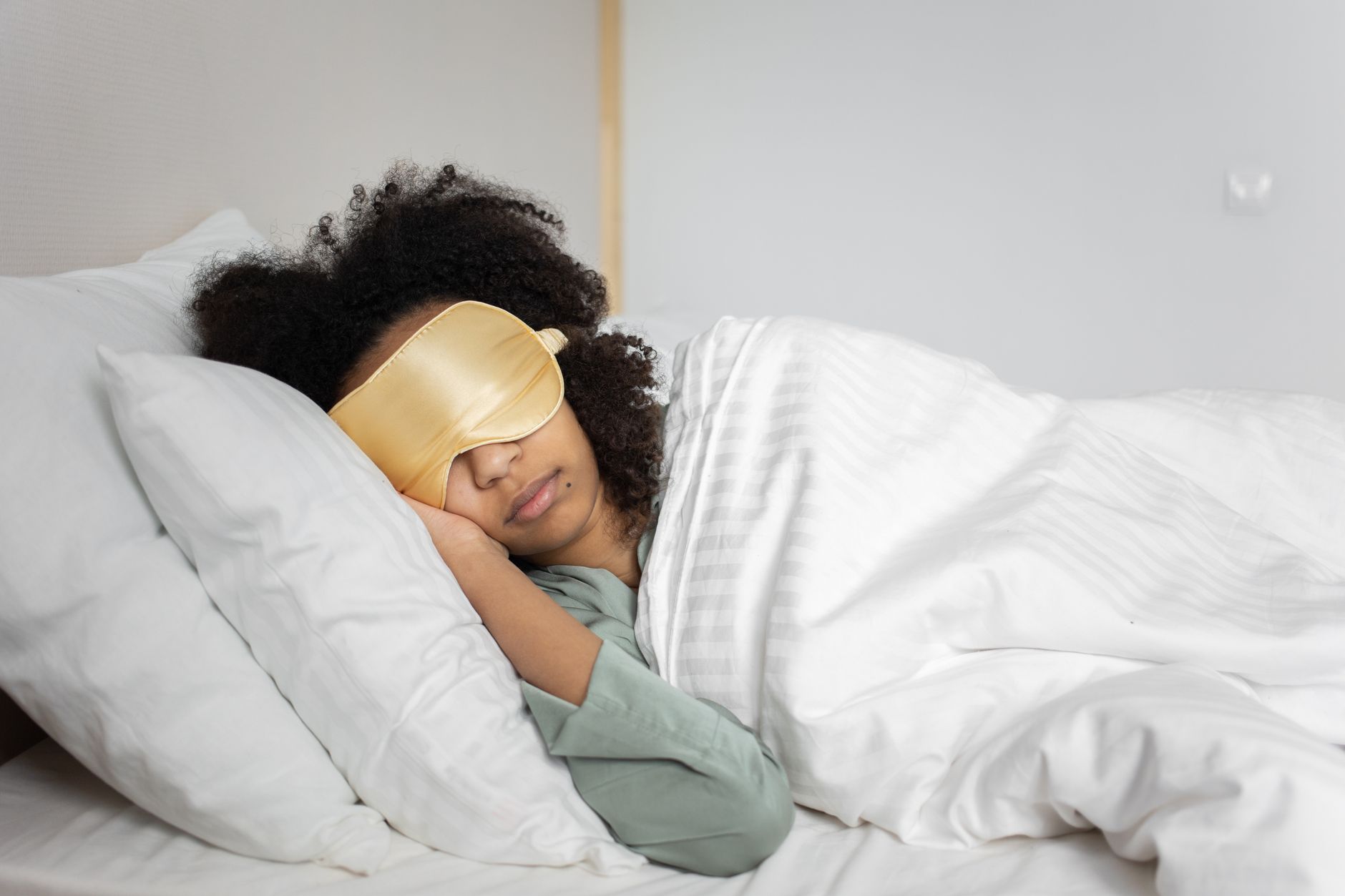 Femme allongée sur le dos, tête calée sur un oreiller